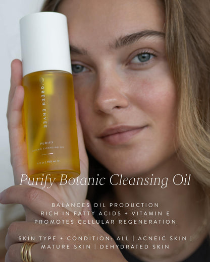 model holding the purify botanic cleansing oil by green envee - reads: balance oil production, rich in fatty acids , vitamin e,  promotes cellular regeneration skin type + conditions: all, aceneic skin, mature skin, dehydrated skin. 