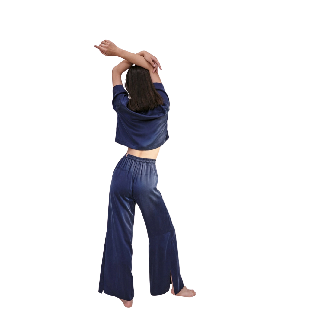 model from the back wearing the lunya washable silk high rise pant set in deep blue at heaven on earth aspen